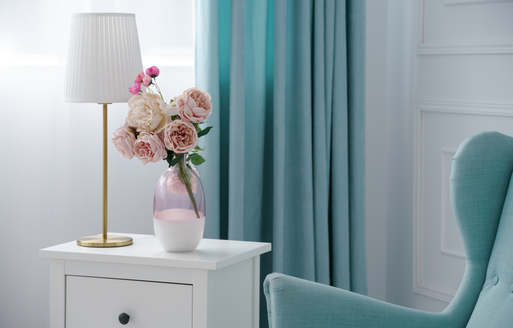 Pink,flower,vase,and,golden,table,lamp,with,blue,armchair