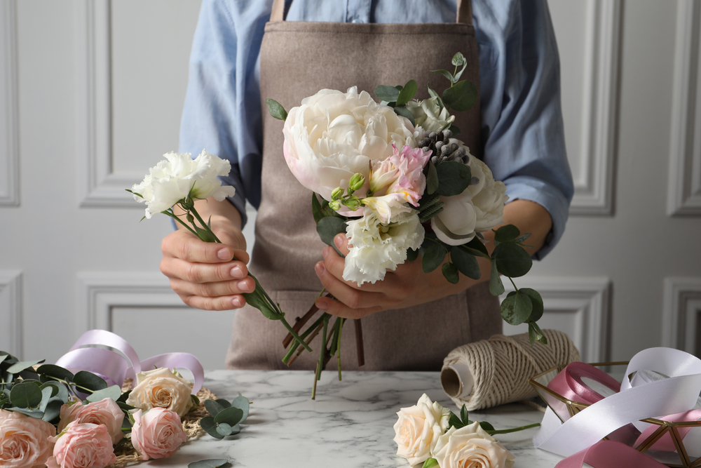 Florist,creating,beautiful,bouquet,at,white,marble,table,,closeup