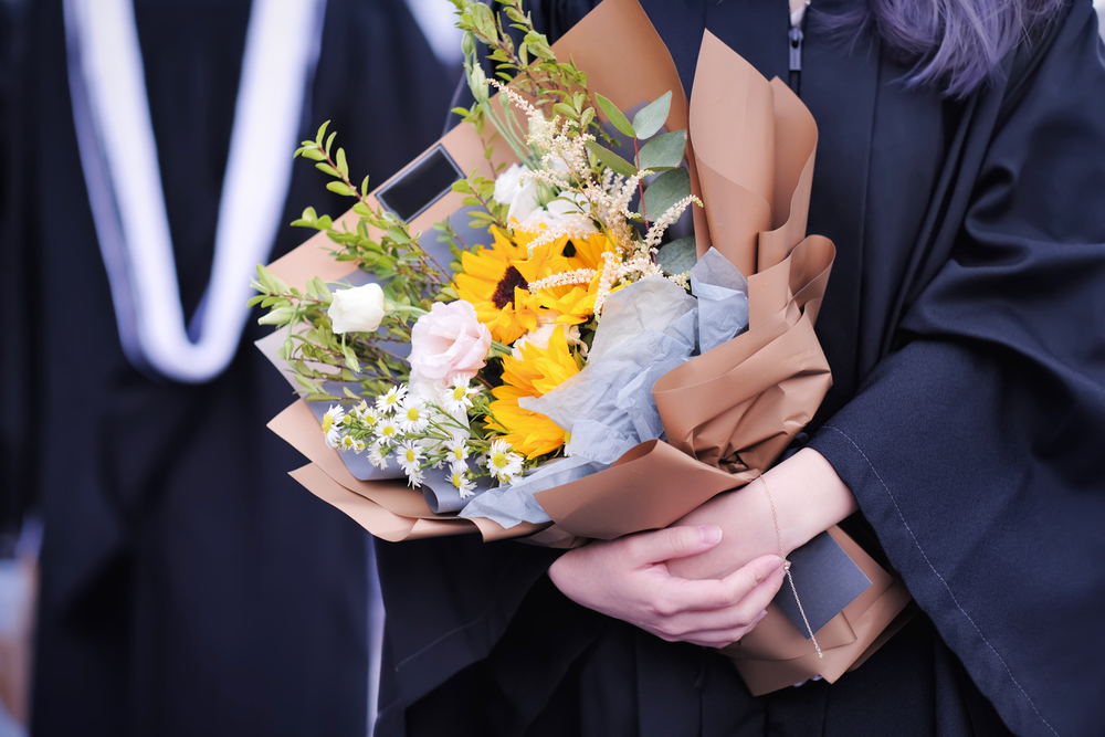 Graduates,in,academic,dresses,holding,beautiful,gorgeous,bouquet,of,fragrant